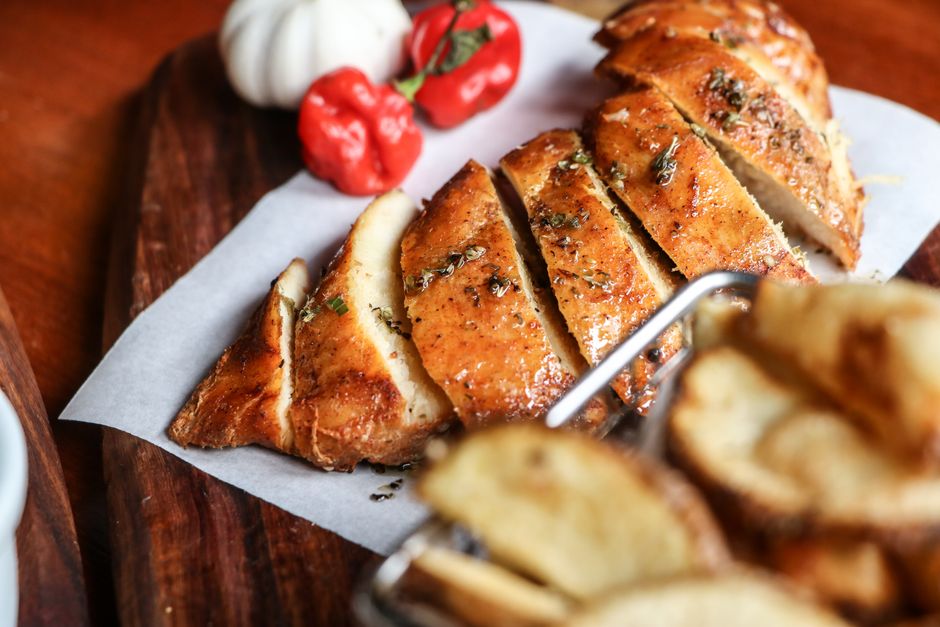 Sliced air fryer chicken breast showing juicy interior on a wooden cutting board