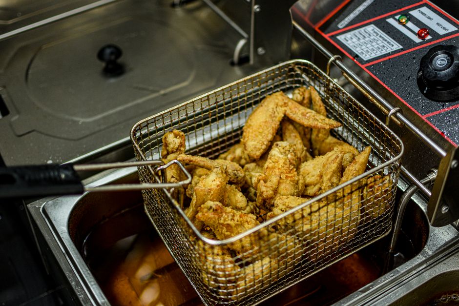 Chicken breast in air fryer basket with golden seasoned crust