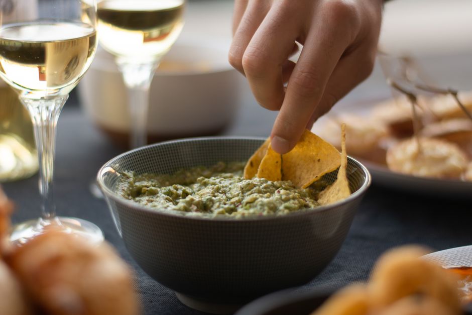 A bowl of fresh chunky guacamole with tortilla chips