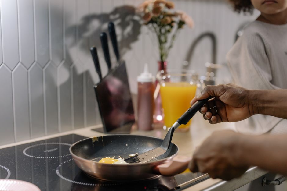 A nonstick frying pan cooking an egg on a stovetop