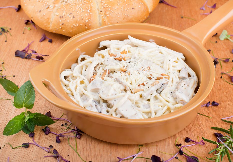 Creamy chicken Alfredo pasta with parsley in a bowl