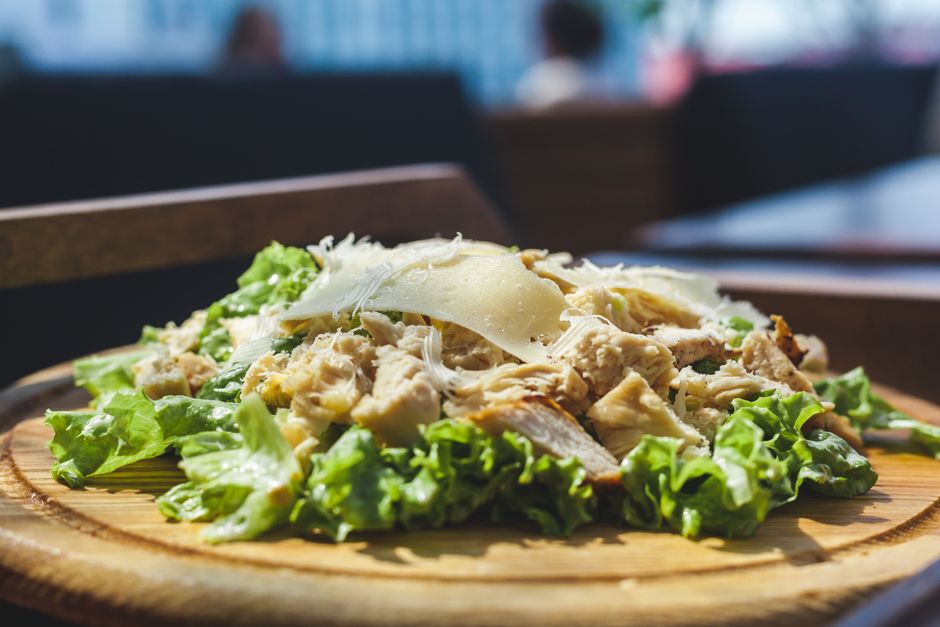 A chicken Caesar wrap cut in half showing romaine and chicken