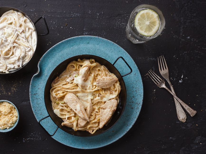 A bowl of creamy high-protein pasta with cottage cheese alfredo sauce and fresh parsley