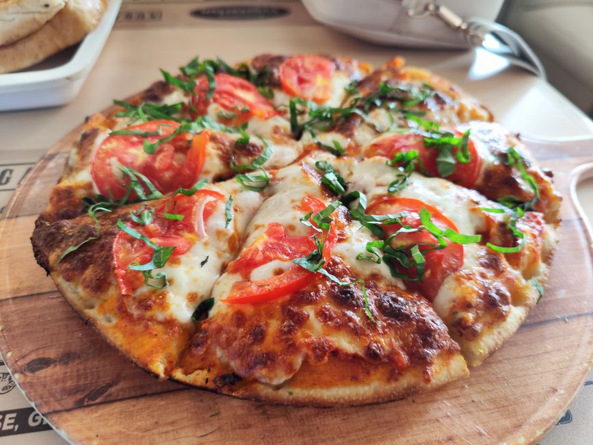 A homemade Margherita pizza with melted mozzarella and fresh basil