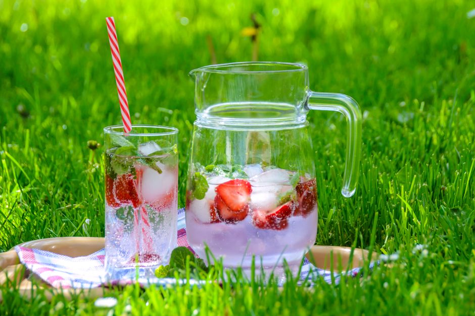 A pitcher of fresh strawberry lemonade with mint and ice