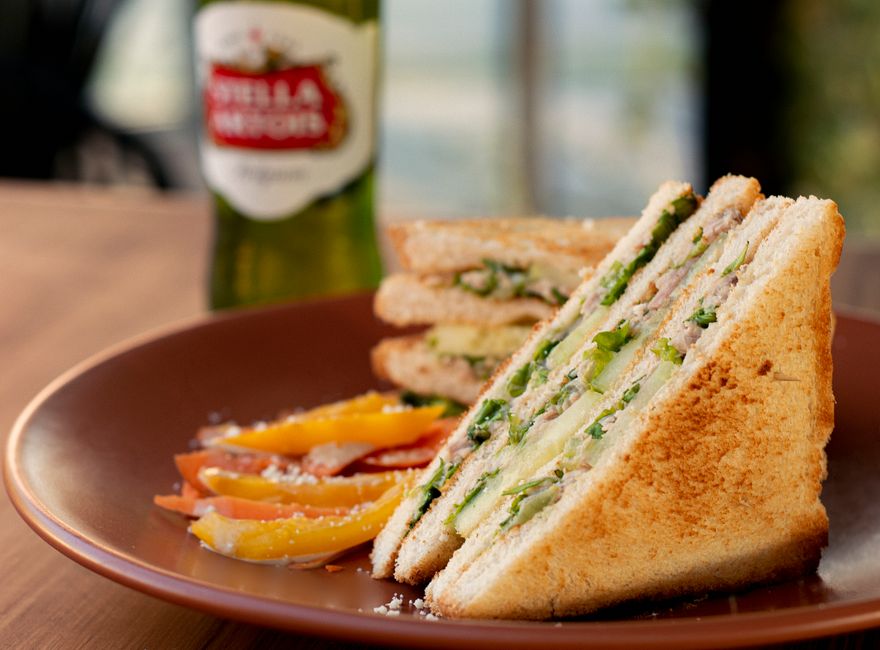 Tasty club sandwich with fresh ingredients served on a rustic plate, perfect for a gourmet meal.