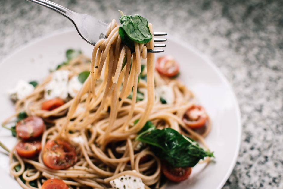 Pasta being tossed with the creamy baked feta and tomato sauce