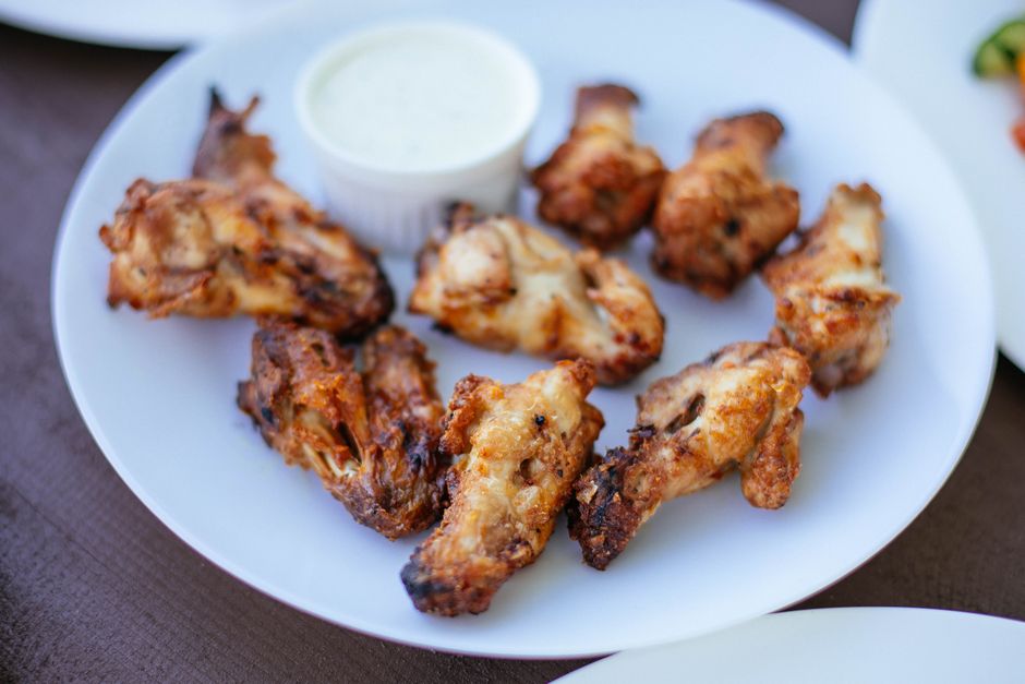 Delicious crispy chicken wings served on a white plate with dipping sauce.