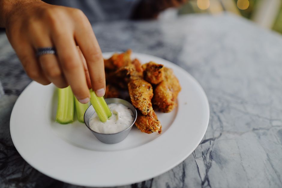 buffalo chicken dip served with celery sticks and tortilla chips