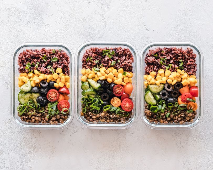 Meal prep containers with lentils, rice, and roasted vegetables