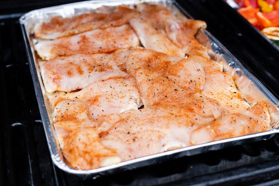 Raw chicken thighs seasoned and arranged on a baking sheet before going into the oven