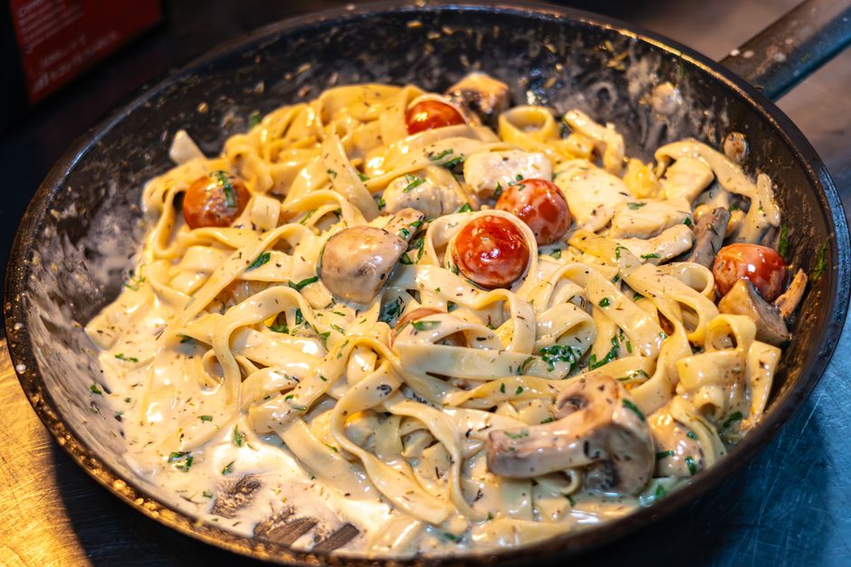Garlic parmesan chicken pasta in a skillet with fresh parsley