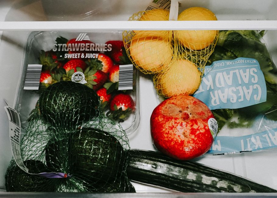labeled glass meal prep containers stored in the refrigerator