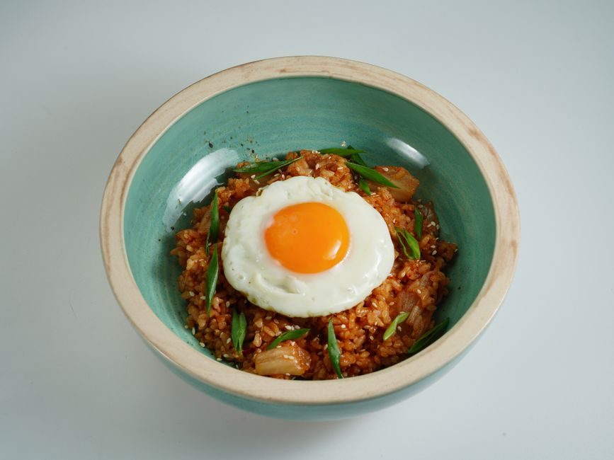 A bowl of kimchi fried rice topped with a fried egg