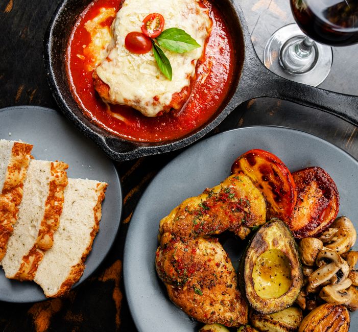 Creamy sun-dried tomato chicken simmering in a skillet with fresh basil
