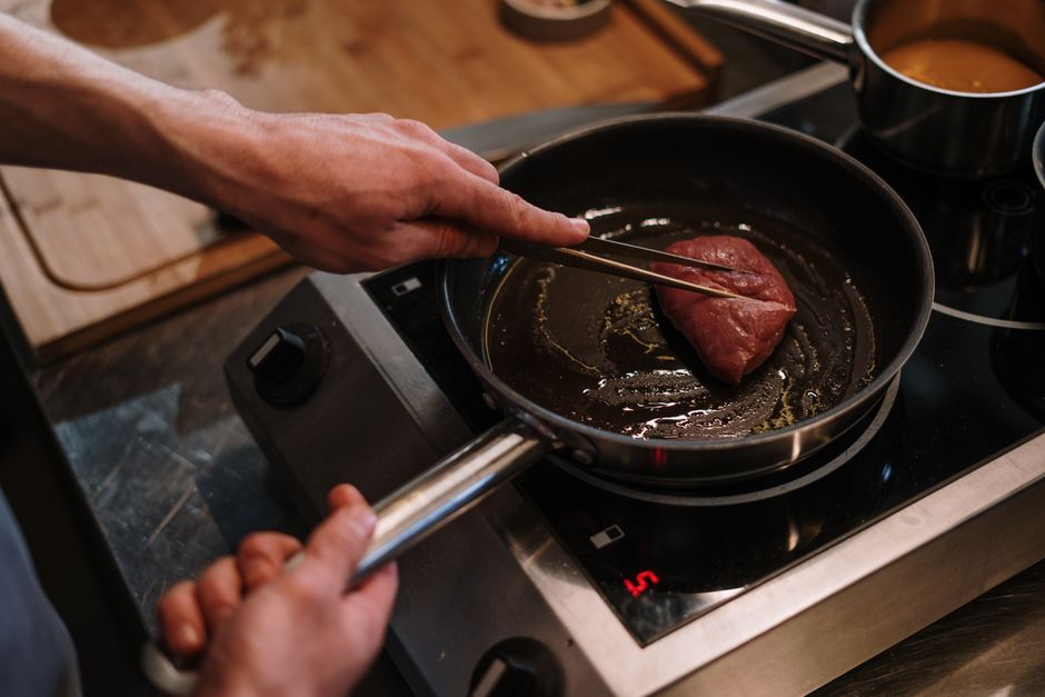 Chuck roast searing in a cast iron skillet before slow cooking