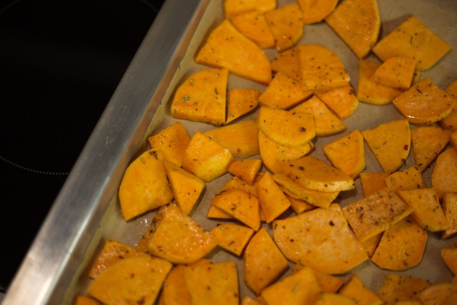 Roasted diced sweet potato with caramelized edges on a sheet pan