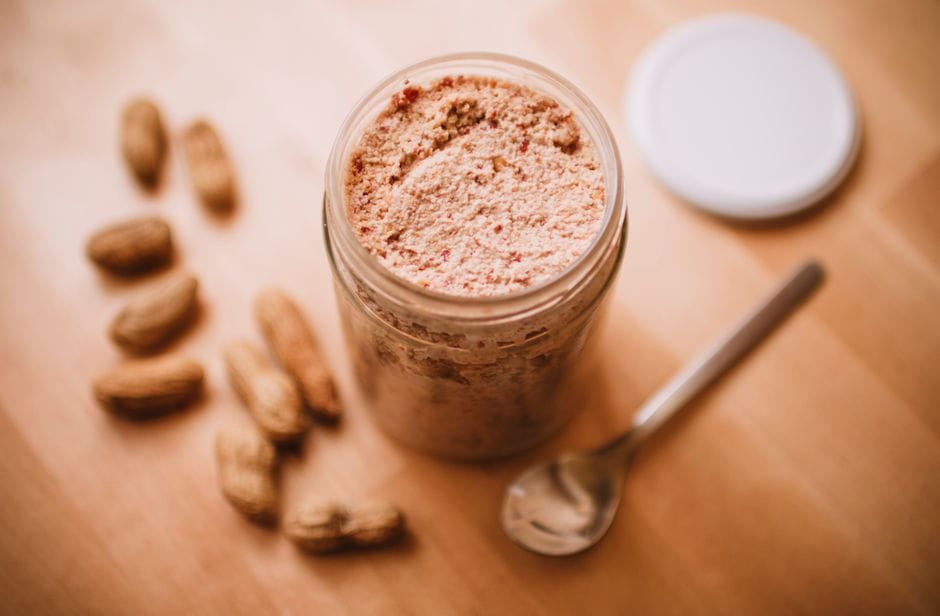 A thick chocolate peanut butter smoothie in a glass topped with a drizzle of peanut butter