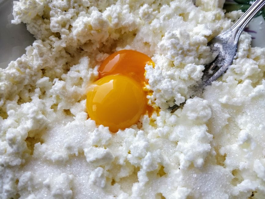 Blender pitcher filled with smooth pale egg white and cottage cheese mixture