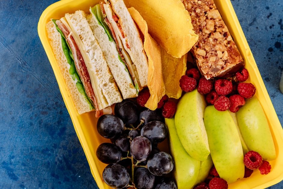 Meal prep container with three egg white bites and fresh berries on the side