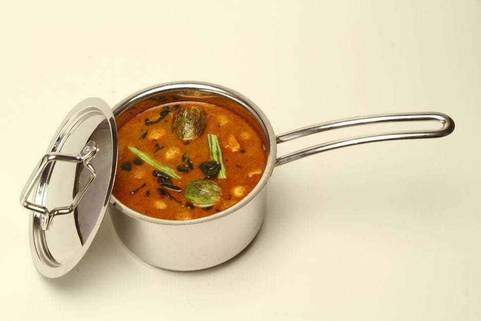 Pot of lentil soup simmering with carrots, celery, and herbs