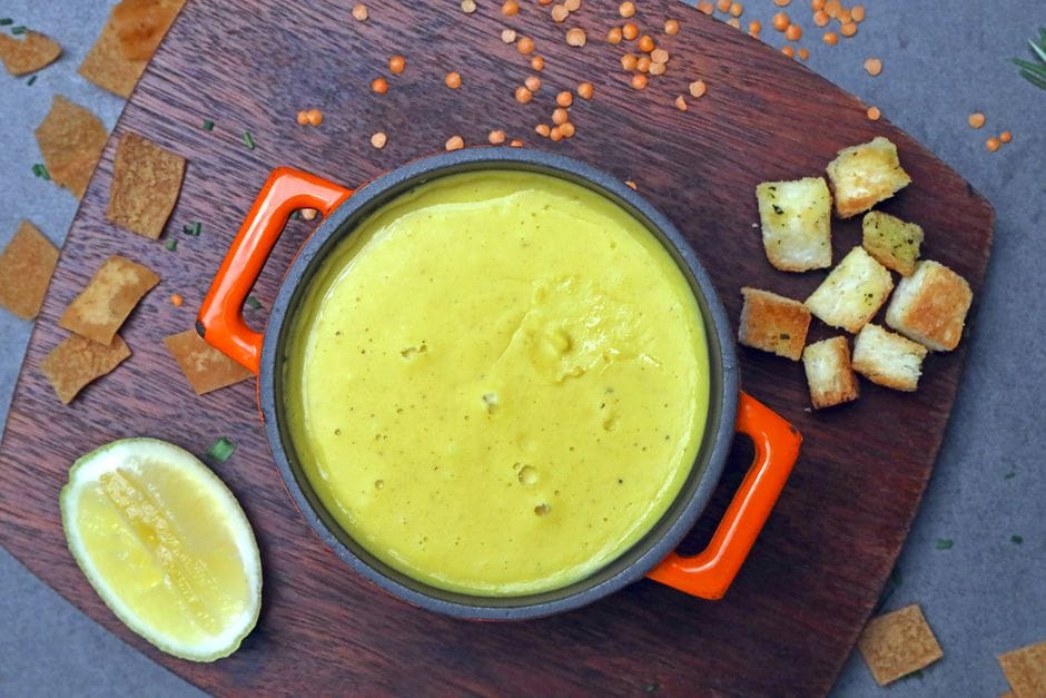 Finished bowl of lentil soup topped with parmesan and a lemon wedge
