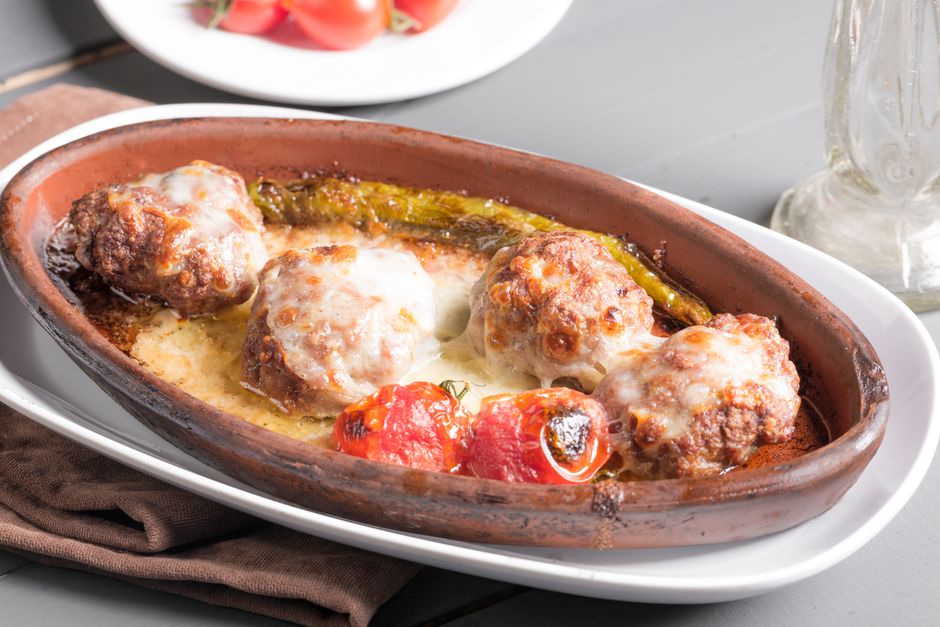 Overhead shot of raw turkey meatballs arranged on a parchment-lined baking sheet