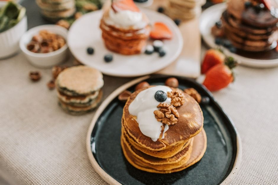Protein pancakes topped with Greek yogurt, nut butter, and sliced banana
