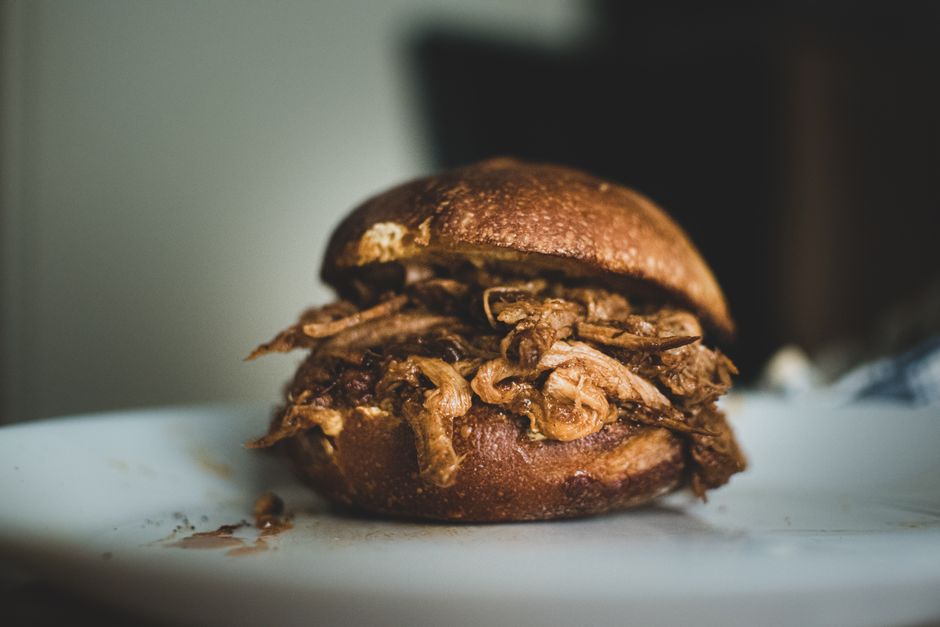 Close-up of a delicious pulled pork sandwich on a plate.