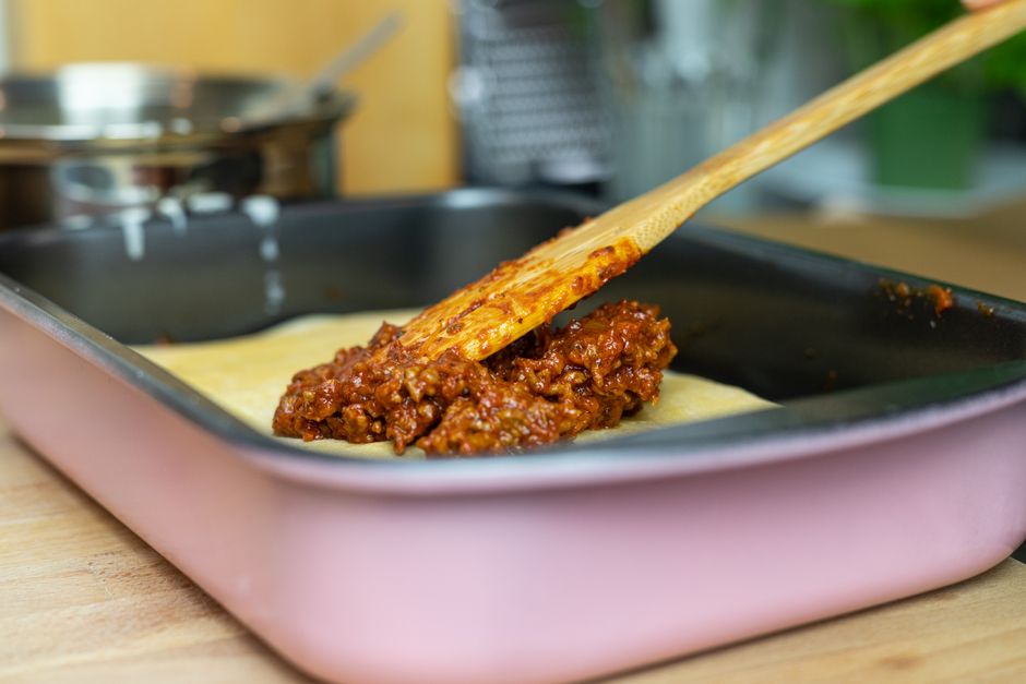 Glass meal prep containers filled with sloppy joe mixture and buns on the side