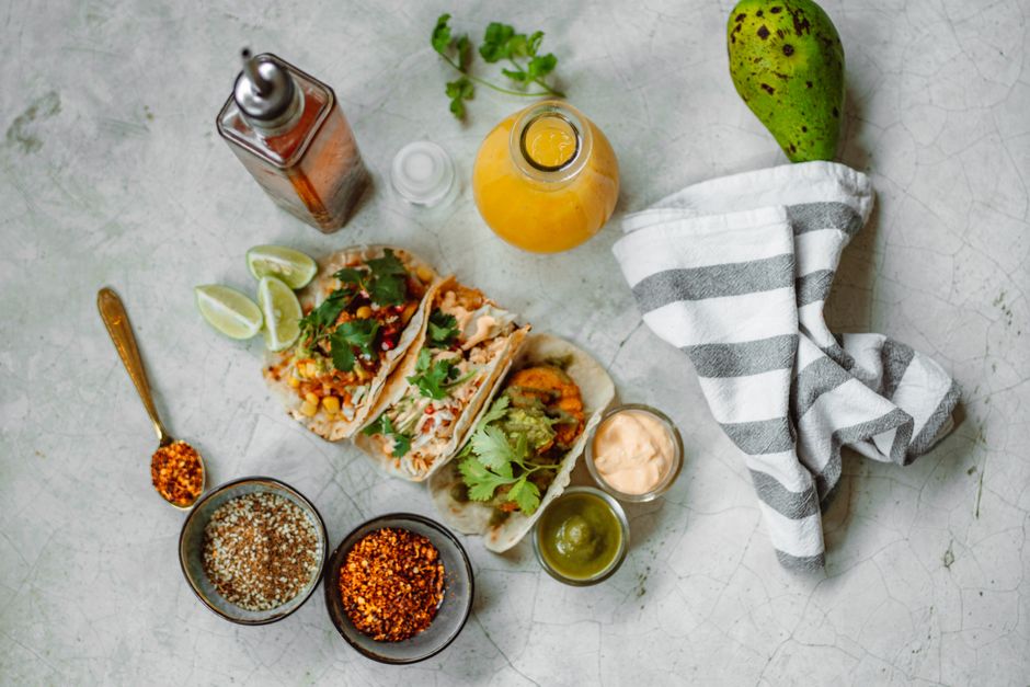 Taco bowl toppings including avocado, lime wedges, and cilantro